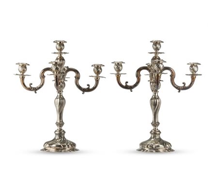 Coppia di candelabri a cinque fiamme in argento a spirale decorati da volute fo