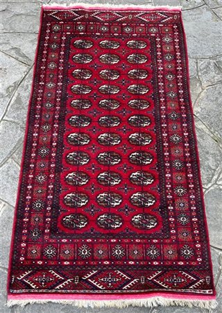 Tappeto Boukhara, Pakistan, secolo XX. Decoro con Gul su fondo rosso (cm 173x95