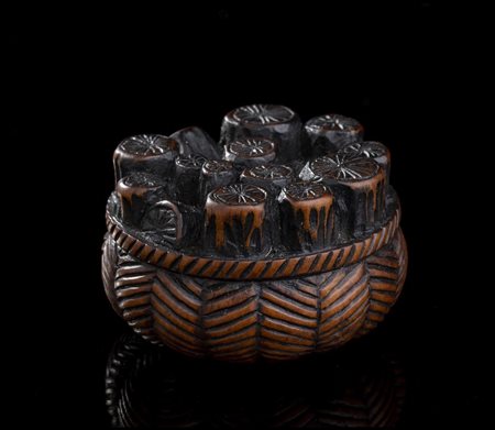 NETSUKE IN LEGNO DI BOSSO CON CESTO DI TIZZONI
Giappone, periodo Edo, XIX secolo