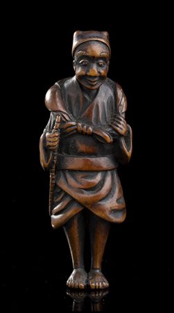 NETSUKE IN LEGNO DI BOSSO CON VIANDANTE
Giappone, fine XVIII-inizio XIX secolo