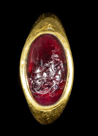 A FINE ROMAN GOLD RING WITH A GARNET INTAGLIO. SCENE OF METAMORPHOSIS.