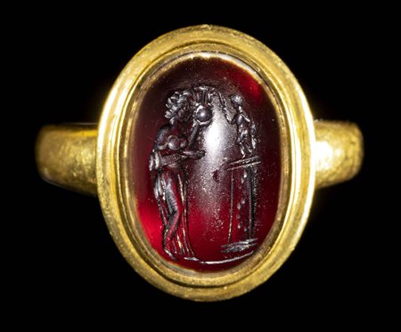 A LARGE ROMAN GARNET CABOCHON INTAGLIO SET IN A MODERN GOLD RING. FEMALE FIGURE OFFERING TO EROS. 