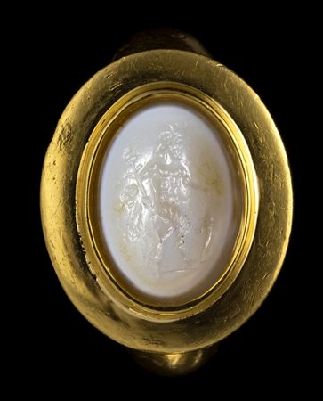A FINE ROMAN CHALCEDONY INTAGLIO SET IN A MODERN GOLD RING. ITHYPHALLIC SATYR HOLDING ATTRIBUTES. 