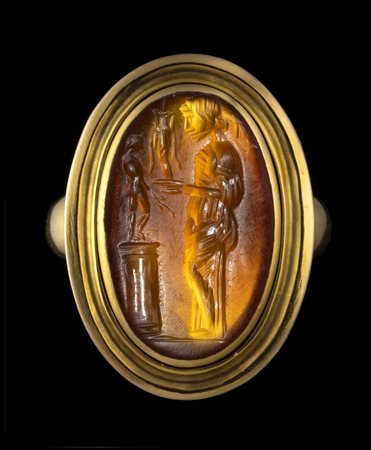 A LARGE ROMAN CARNELIAN INTAGLIO SET IN A  GOLD RING. OFFERER IN FRONT OF AN IDOL.