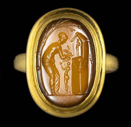 A LARGE ROMAN CARNELIAN INTAGLIO SET IN A MODERN GOLD RING. VENUS MAKING OFFERS TO PRIAPUS. 