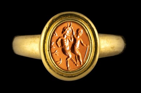 A ROMAN RED JASPER INTAGLIO SET IN A MODERN GOLD RING. EROTIC SCENE WITH INSCRIPTION. 