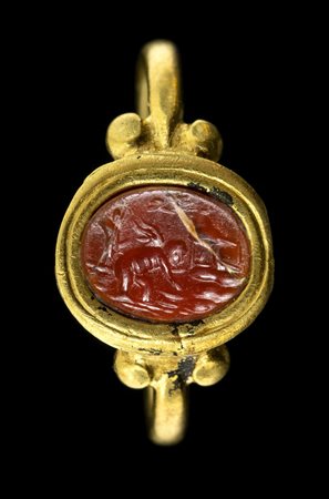 A ROMAN GOLD RING SET WITH A CARNELIAN INTAGLIO. EROS MAKING OFFERS. 