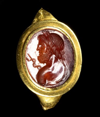 A ROMAN FRAGMENTARY GOLD RING SET WITH A CARNELIAN INTAGLIO. BUST OF ASCLEPIOS. 
