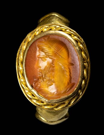 AN EASTERN ROMAN CARNELIAN INTAGLIO SET IN A REVIVAL GOLD RING. HEAD OF JUPITER SERAPIS.
