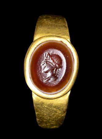 A ROMAN GOLD RING SET WITH A CARNELIAN INTAGLIO. BUST OF A YOUTH.