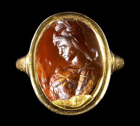 A ROMAN CARNELIAN INTAGLIO SET IN A GOLD RING. BUST OF ATTIS. 