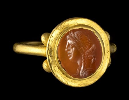 A ROMAN GOLD RING SET WITH A CARNELIAN INTAGLIO. BUST OF A GODDESS. 