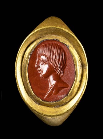 A ROMAN RED JASPER INTAGLIO SET IN A GOLD RING. BUST OF A YOUTH. 