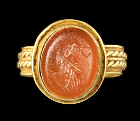 A LATE ROMAN GOLD RING SET WITH A CARNELIAN INTAGLIO. EAGLE HOLDING A LAUREL WREATH. 