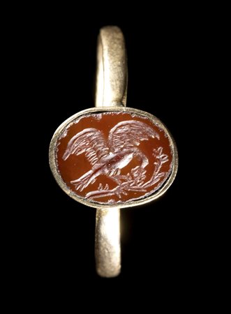 A ROMAN RED JASPER INTAGLIO SET IN A GOLD RING. EAGLE. 