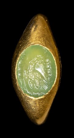 A ROMAN GOLD RING SET WITH A GREEN CHALCEDONY INTAGLIO.EAGLE BETWEEN MILITARY STANDARDS.