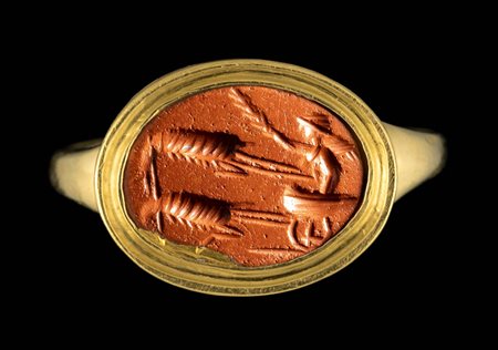  A ROMAN RED JASPER INTAGLIO SET IN A GOLD RING. EROS ON A CHARIOT PULLED BY TWO SHRIMPS. 