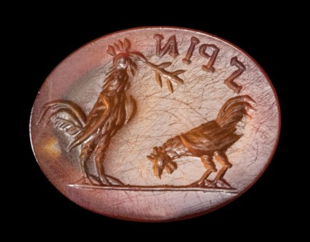 A ROMAN CARNELIAN INTAGLIO. TWO ROOSTERS WITH AN INSCRIPTION. 