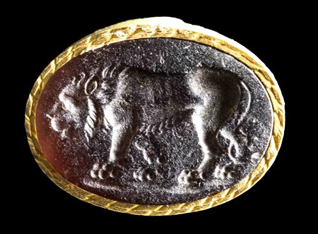 A ROMAN GLASS INTAGLIO SET IN A GILDED PAPER FRAME. LION. 