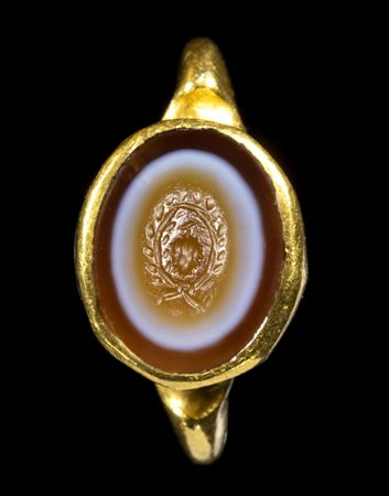 A ROMAN GOLD RING SET WITH AN AGATE INTAGLIO. BUNCH OF GRAPE IN A LAUREL WREATH. 