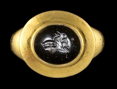 A ROMAN ONYX INTAGLIO SET IN A MODERN GOLD RING. GRYLLOS. 