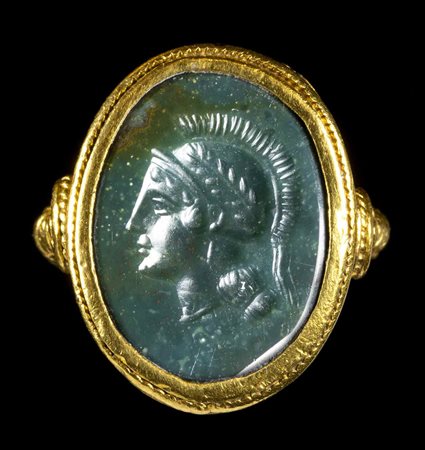 A GREEN JASPER INTAGLIO SET IN A REVIVAL GOLD RING. HEAD OF ATHENA. 