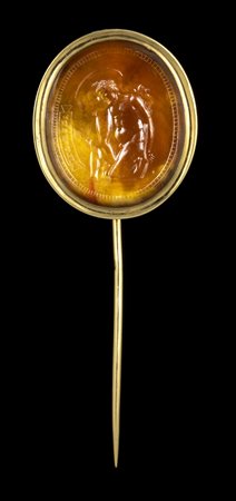 A FINE NEOCLASSICAL CARNELIAN INTAGLIO SET IN A GOLD STICK PIN. MENELAUS CARRYING THE BODY OF PATROCLUS.