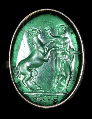 A GREEN GLASS IMPRESSION SET IN A SILVER RING - FOB. MAN WITH AN HORSE. 