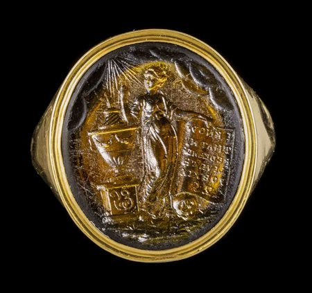 A GLASS IMPRESSION SET IN A GEORGIAN  GOLD RING. ALLEGORICAL MOURNING SCENE. 