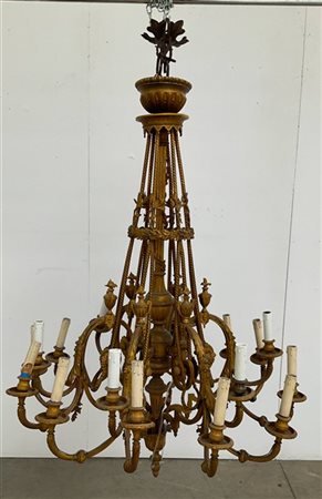 Lampadario in bronzo dorato a sedici bracci con decoro a volute fogliate sormon