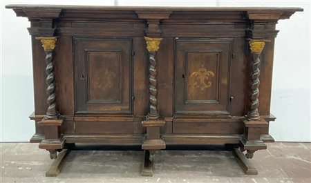 Antica credenza in noce a due ante pannellate e due cassetti. Montanti a colonn