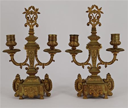 Coppia di candelabri a due fiamme in bronzo dorato decorati a volute e foglie (