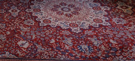 Tappeto persiano a fondo rosso e motivi floreali in blu