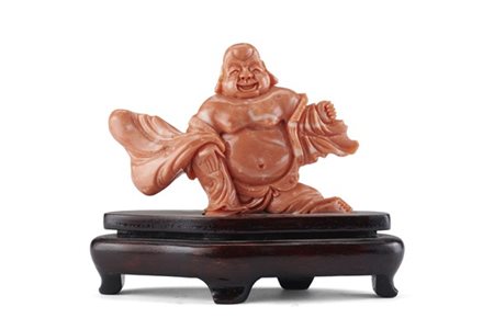 Figura di Buddha in corallo con base di legno. Cina, secolo XX (lordo g 175) (c