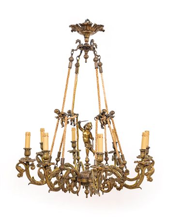 Lampadario in bronzo dorato a otto luci cm 70x75 caratterizzato da figure di...