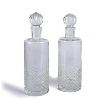 Coppia di bottiglie in vetro incolore corpi cilindrici lisci, intagliati a...