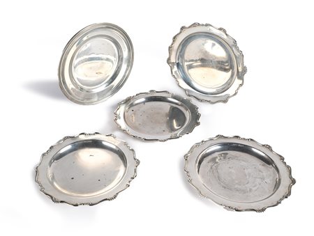 Cinque piatti diversi in argento quattro con volute e perline lungo il...