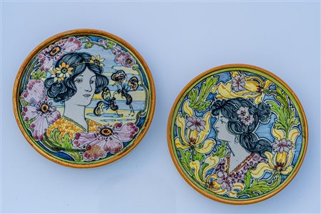 Coppia di piattini Art Nouveau con figure muliebri in serti di fiori e insetti.    Manifattura Molaroni Pesaro degli anni Venti del XX secolo