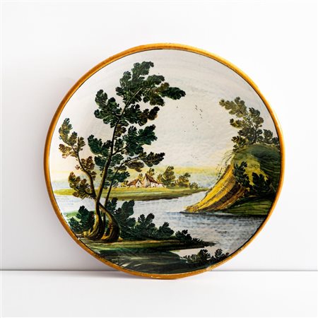 Piatto in maiolica decorato con paesaggio fluviale   Manifattura di Castelli della metà del XX secolo