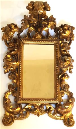 Specchiera a cartoccio in legno intagliato e dorato. XVII secolo. 