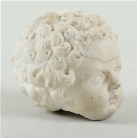 A white marble head of a putto, ca. 1700. H.: 7,5; Diam.: 8 cm.