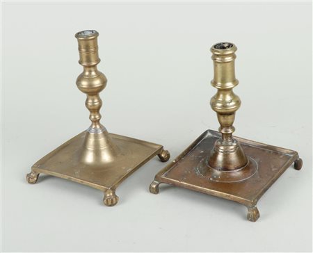 A lot of two Spanish brass candlesticks on a square base and legs, 17th/18th...