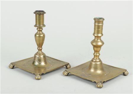 A lot of two Spanish brass candlesticks on a square base and legs, 17th/18th...