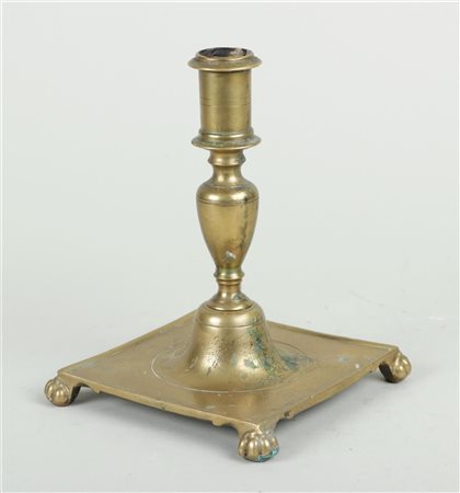 A Spanish brass candlestick on a square base and legs, 17th/18th century. H....