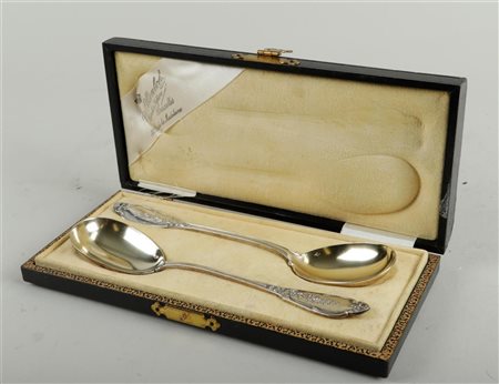 A lot consisting of (2) silver serving spoons with gilded bowls, in original...