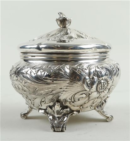 A silver sugar bowl with embossed floral motifs in the body and lid, marked...