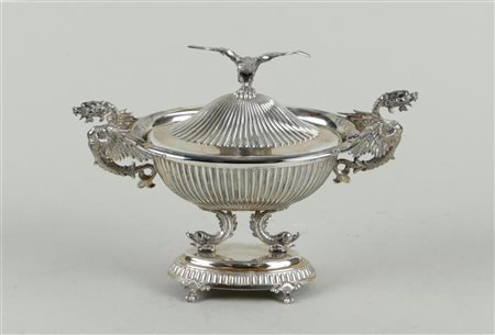 A silver fluted lidded bowl carried by dolphins on a foot. The bowl decorated...