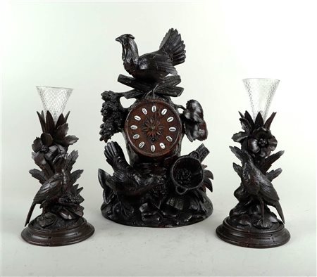 A wooden Garniture de Cheminée decorated with various birds. The clock...