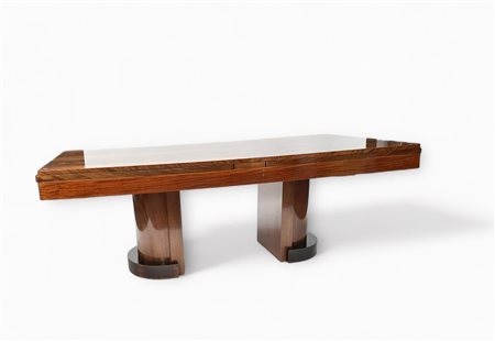 A large Art Deco dining table, extendable to 12 people. On top a hard glass...