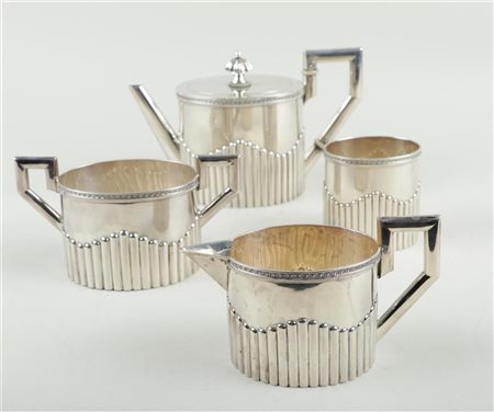 A silver tea set consisting of a teapot, cream set, and a spoon vase, marked...